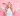 young blonde woman holding money against pink wall