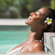 beautiful black woman with flower in hair lounging in spa for wellness