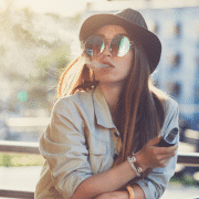 woman with sunglasses and hat on vaping hash